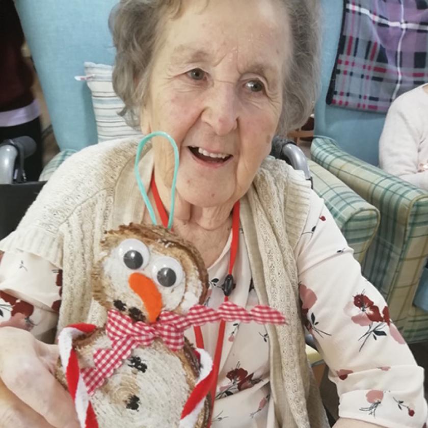 Sanctuary Care Resident Betty Barrott holding the hand-crafted snowman she created as part of the daily advent calendar activities over Christmas