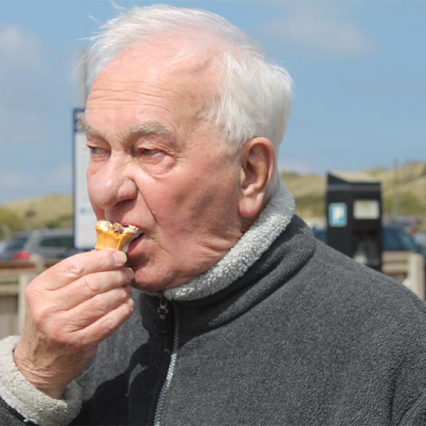 Sanctuary Care resident Ken Andrews eating an ice cream at the beach