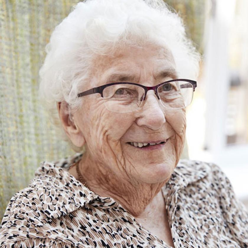 Elderly woman sitting in a chair smiling